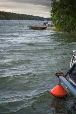 Dubalı bir nehir kıvrımı ve bulutlu bir günde beyaz bir tekne.