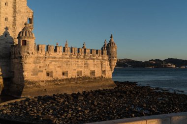 Lisbon, gün batımında Belem Kulesi 'nin manzarası, Tagus Nehri alçak sularda ve kayalık plajda su yok.