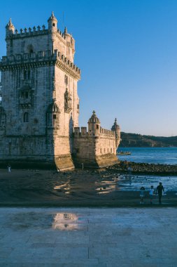 Lizbon, Portekiz, 27.09.2019 Belem Kulesi manzarası, gelgit manzarası, ıslak sahildeki insanlar, öğleden sonra gölgeli yerler.