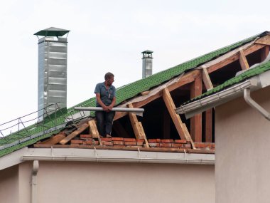 Tamir aşamasında çatıdaki işçi.