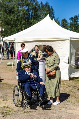 İkinci Dünya Savaşı gazisi tekerlekli sandalyede ve yoldaşı.