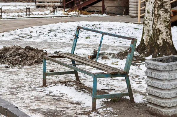 Oude gebroken houten bankje met ijzeren frame. — Stockfoto