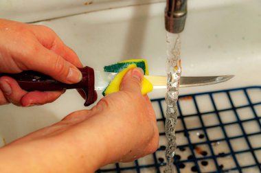 Bıçak lavaboda yıkanmış, güçlü bir su akıntısının altında.