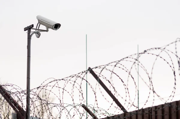 CCTV camera over the barbed wire fence. Focus on CCTV camera