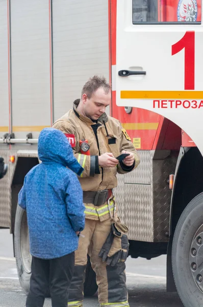 ロシアのペトロザヴォドスク 2020年2月20日消防士はスマートフォンと男の子で見て — ストック写真