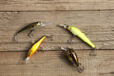 Balıkçı yemleri gri tahtada sallanıyor.