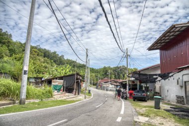 Perak, Malezya. 9 Kasım 2019: Pangkor Adası 'nda seyahat ederken yeşillik yaprakları boyunca asfalt yol yolunun güzel manzarası.