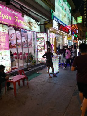 Dalat, Vietnam - December 12, 2019 Scene of crowded busy night marketplace with street vendor selling produce and wares on the sidewalk at Central Dalat Night 