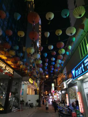 Dalat, Vietnam - December 12, 2019 Scene of crowded busy night marketplace with street vendor selling produce and wares on the sidewalk at Central Dalat Night 