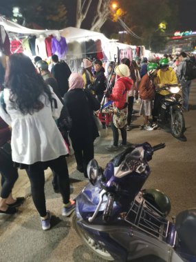 Dalat, Vietnam - December 12, 2019 Scene of crowded busy night marketplace with street vendor selling produce and wares on the sidewalk at Central Dalat Night 