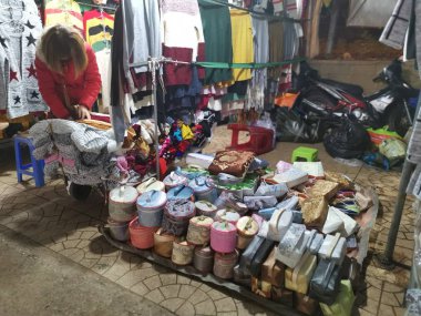 Dalat, Vietnam - December 12, 2019 Scene of crowded busy night marketplace with street vendor selling produce and wares on the sidewalk at Central Dalat Night 