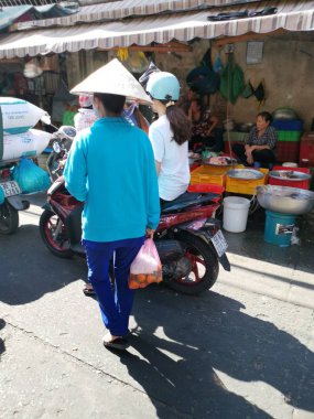 Ho Chi Minh City, Vietnam - December 15, 2019 Crowded daytime marketplace with street vendor selling variety produces- wet or day and wares on the sidewalk at Ho Chi Minh City market.