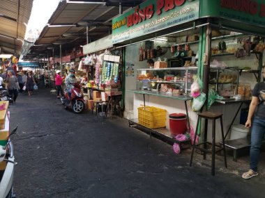 Ho Chi Minh City, Vietnam - December 15, 2019 Crowded daytime marketplace with street vendor selling variety produces- wet or day and wares on the sidewalk at Ho Chi Minh City market.