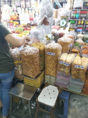 Ho Chi Minh City, Vietnam - December 15, 2019: Scene of stalls selling variety nuts, junk foods and jewellery are displayed and sold inside the Tong Thau APG Market at Ho Chi Minh City.