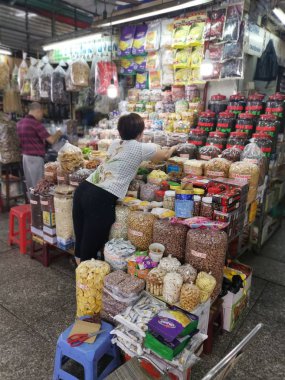 Ho Chi Minh City, Vietnam - December 15, 2019: Scene of stalls selling variety nuts, junk foods and jewellery are displayed and sold inside the Tong Thau APG Market at Ho Chi Minh City.
