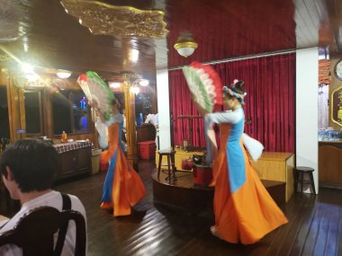 Ho Chih Minh, Vietnam. December 15,2019: Scene of lady performance cultural dance while tourists having dinner on the Saigon river cruise at Ho Chih Minh Lake.