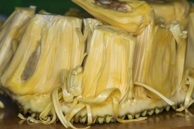 Bir Jackfruit kes ve lezzetli sarımsı soğanları ayır..