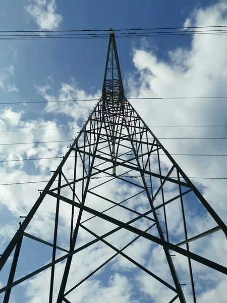 lookup daytime sky with electric tower foreground