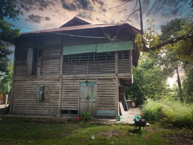evening scene at the old double-storey  deserted wooden home.