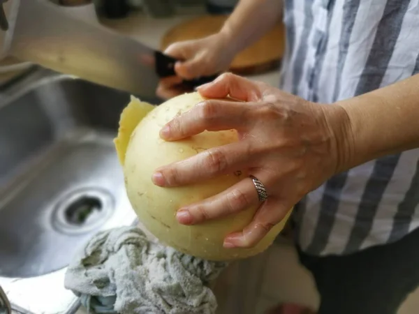 Cięcie Dojrzałego Melona Miodu Przy Zlewie Kuchennym — Zdjęcie stockowe