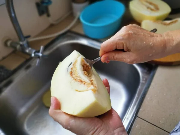 Cięcie Dojrzałego Melona Miodu Przy Zlewie Kuchennym — Zdjęcie stockowe