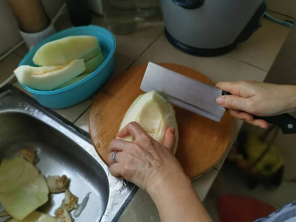 Cięcie Dojrzałego Melona Miodu Przy Zlewie Kuchennym — Zdjęcie stockowe