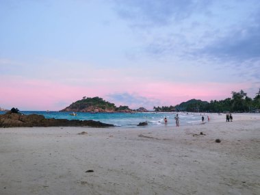 Trengganu, Malezya. 24 Haziran 2019: Redang Adası kıyı şeridinde akşam plaj istirahatının tadını çıkaran insanların veya turistlerin sahne ve aktiviteleri. 