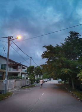 Perak, Malezya. 22 Mayıs 2020: Sabahın erken saatlerinde Kg Koh Garden 'da yol kenarında yürüyüş yapan ya da egzersiz yapan bir adam.