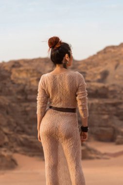 Şeffaf, uzun elbiseli bir kız. Sırtını bize dön ve çöle bak. Ürdün 'de vuruldu..