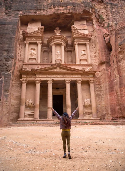 Een meisje staat alleen in Petra voor Al-Khazne, spreidt haar armen uit.. — Stockfoto