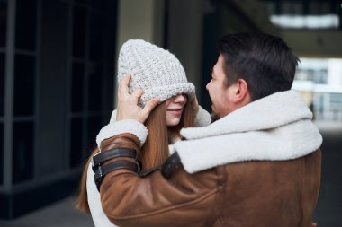 Komik adam kız arkadaşının gözlerini şapkanın altına gizliyor..