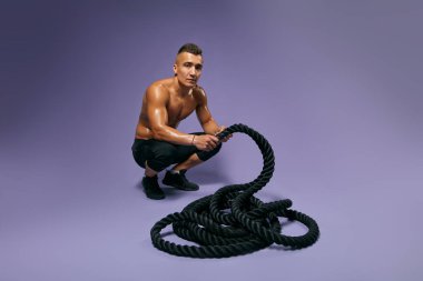 Yakışıklı adam spor merkezinde abteak yapıyor.