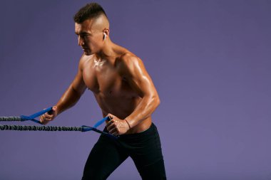 Islak terli sporcu spor merkezinde genişletici ile çalışıyor.