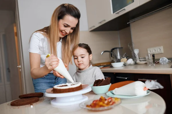 Cheerful happy mother showing how to decorate dessert — Stock Photo, Image