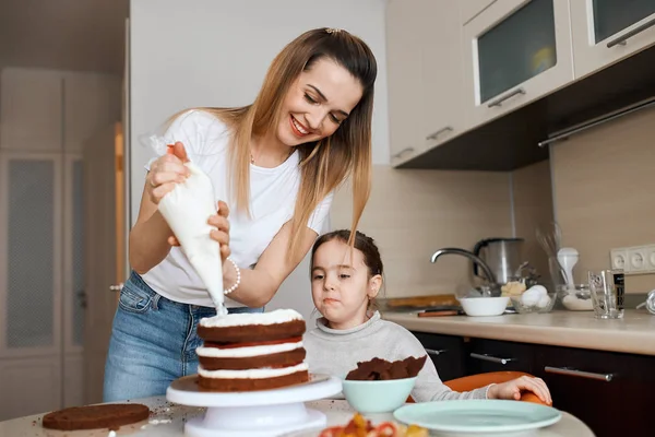 Cheerful woman making cake for guests — Stock Photo, Image