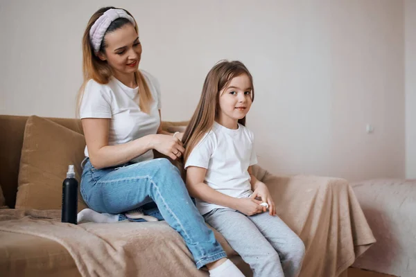 Attrayant femme faire des cheveux pour sa fille, prpearing elle à une fête — Photo