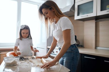 Sarışın, çalışkan bir anne ve oklavalı güzel bir kız.
