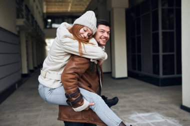 Kapalı gözleri olan komik çılgın kız erkek arkadaşlarının sırtında oturmaktan zevk alıyor.