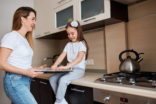 Šťastná radostná maminka a její dcera cvičí kuchařské dovednosti — Stock fotografie