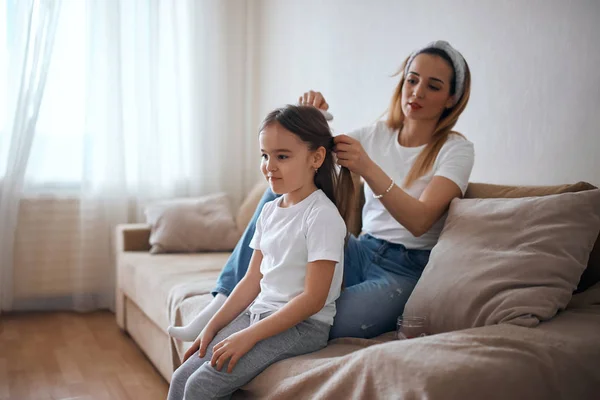 Mommy brushing her little daughters hair in baedroom — Stock Photo, Image