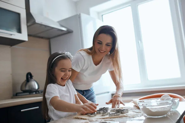 Litle lovely girl is happy as she has cooked biscuits for the first time — Stock Photo, Image