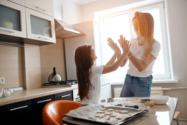 Happy mommy and her daughter playing in the kitchen — Stock Photo, Image