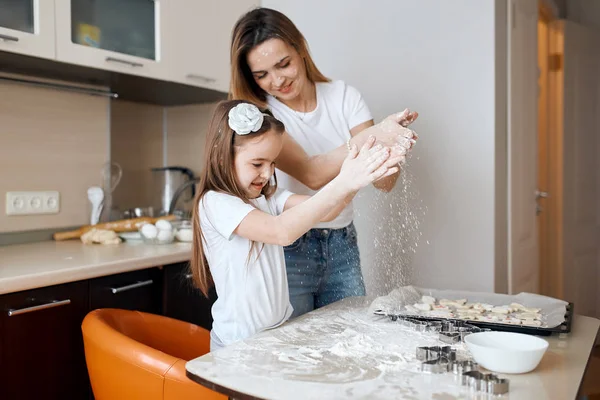 family enjoying preparing cake. woman and kid klapping hands