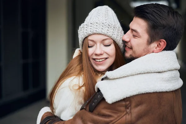 Cara barbudo alegre abraçando sua namorada, ele está se encontrando com ela na estação — Fotografia de Stock
