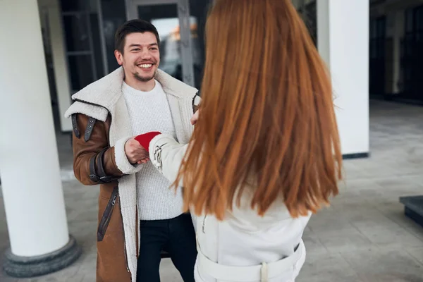 young happy black-haired man with bearded and moustache flirting with ginger girl