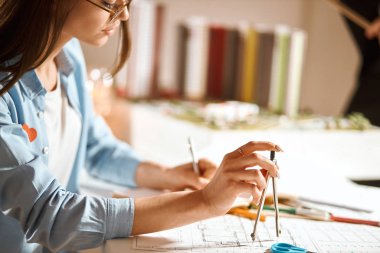 Pensive young beautiful architect making circles