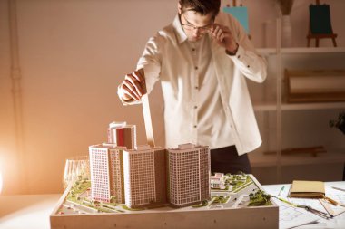 architect checking the measurements of the model of dwelling