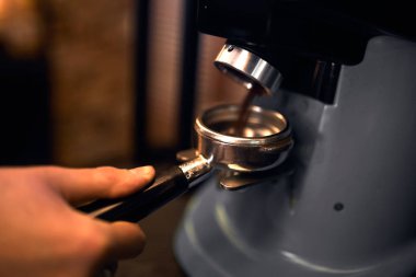 pocess of grinding coffee, close up side view cropped photo