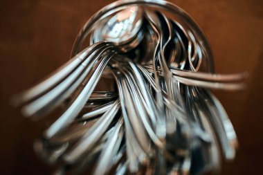 Stack of shining spoon is into the bowl, kitchen equipment