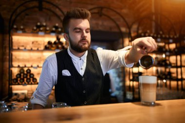 handosme bearded man is keen on making coffee